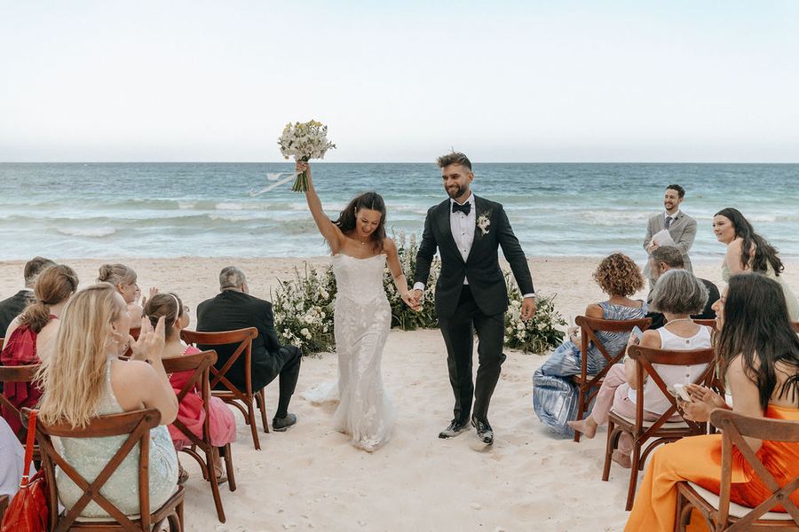 Audrey & Jorge walking back down the aisle among their guests