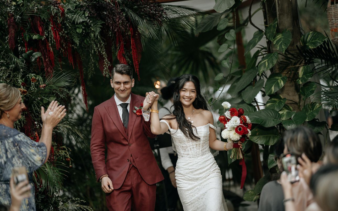 Emily & Mitchell walk back down the aisle as their guests cheer