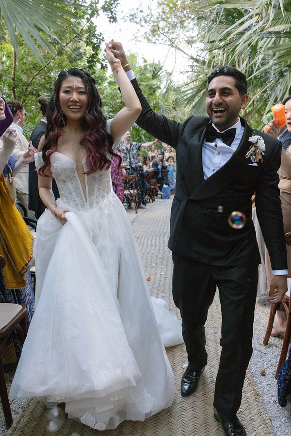 Summer & Steven walking back down the aisle as their guests cheer at Vesica